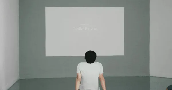 Man sitting with the back staring at a blank canvas  