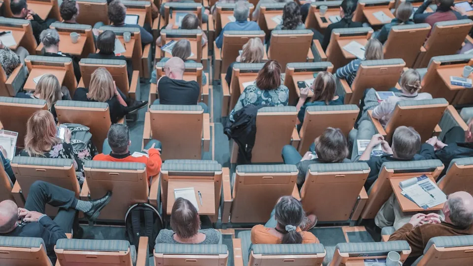 high-angle photography of group of people sitting at chairs