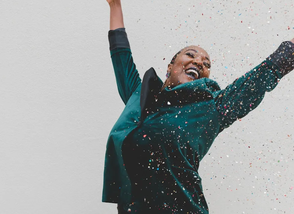 woman in green jacket raising her hands