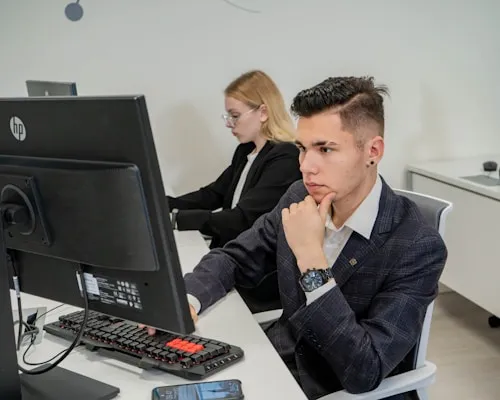 a man sitting at a desk in front of a computer