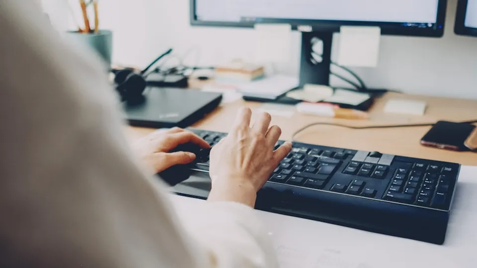 a person is typing on a computer keyboard